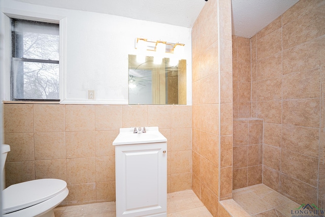 bathroom featuring vanity, toilet, and tile walls