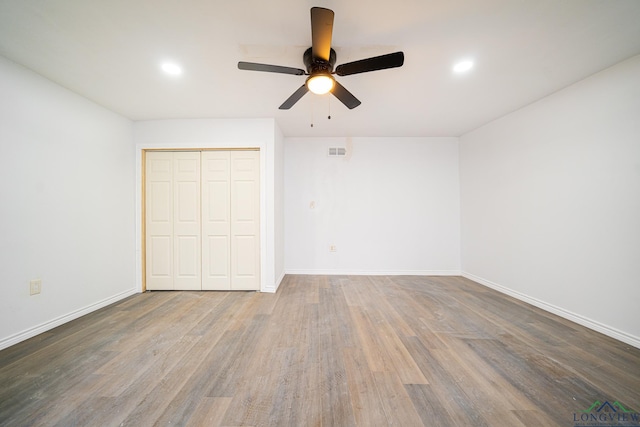 unfurnished bedroom with dark wood-type flooring, a closet, and ceiling fan