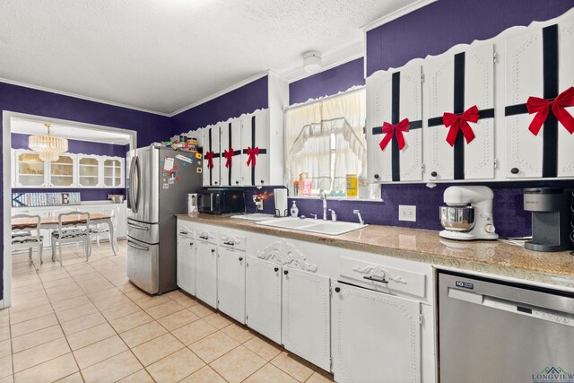 7869 Arrowwood Rd, Gilmer, TX 75644 - kitchen with appliances with stainless steel finishes, a sink, light tile patterned flooring, white cabinetry, and ornamental molding