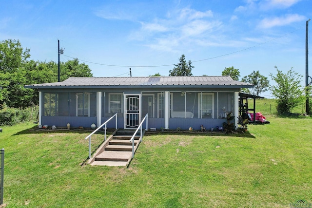 7869 Arrowwood Rd, Gilmer, TX 75644 - view of front of house featuring a sunroom, a front lawn, and metal roof