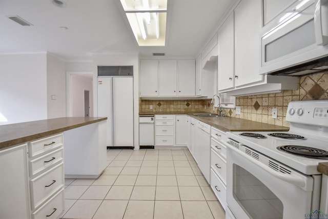 kitchen with sink, white cabinetry, light tile patterned flooring, white appliances, and decorative backsplash