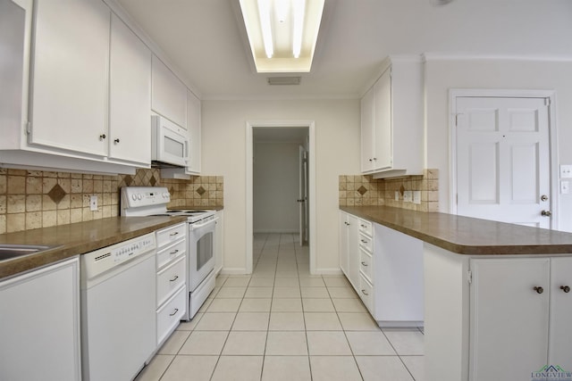 kitchen featuring kitchen peninsula, white cabinetry, tasteful backsplash, light tile patterned flooring, and white appliances