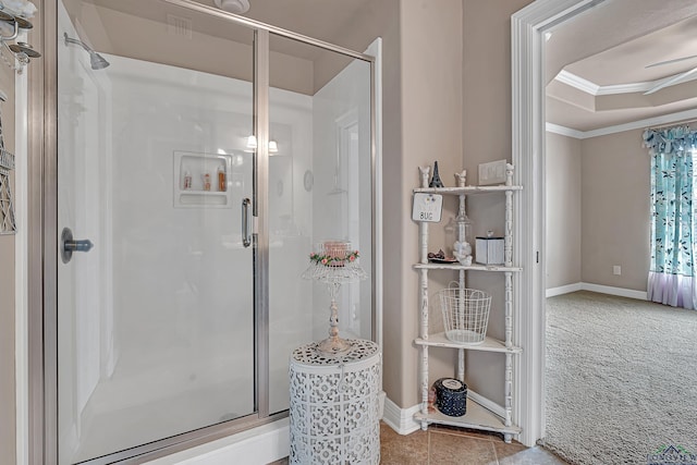 full bath with ornamental molding, a tray ceiling, a shower stall, and baseboards