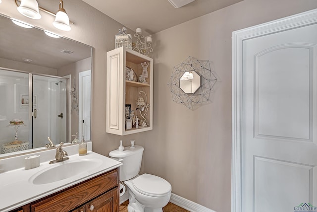 bathroom featuring toilet, visible vents, vanity, baseboards, and a shower stall