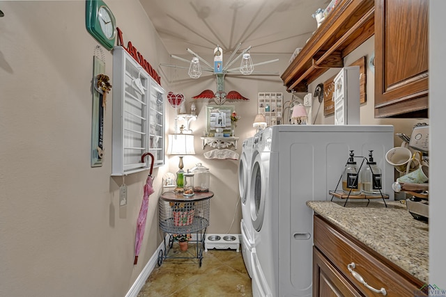 laundry room with light tile patterned floors, washer and clothes dryer, cabinet space, and baseboards