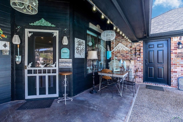 entrance to property featuring a patio area and brick siding