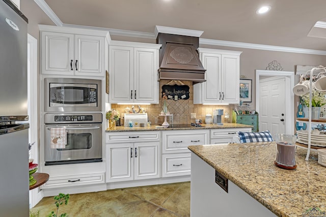 kitchen featuring crown molding, custom exhaust hood, decorative backsplash, appliances with stainless steel finishes, and white cabinets