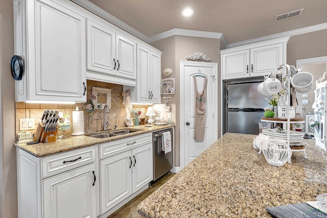 kitchen featuring visible vents, decorative backsplash, stainless steel appliances, white cabinetry, and a sink