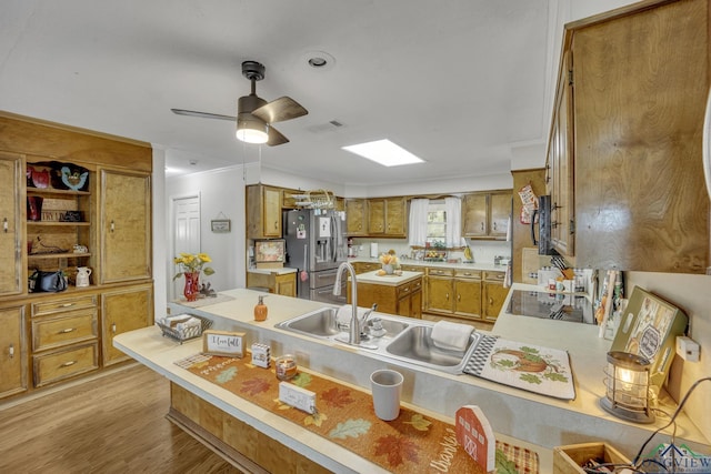 1216 Fm 2468, Center, TX 75935 - kitchen featuring stainless steel refrigerator with ice dispenser, brown cabinets, a sink, light countertops, and ornamental molding