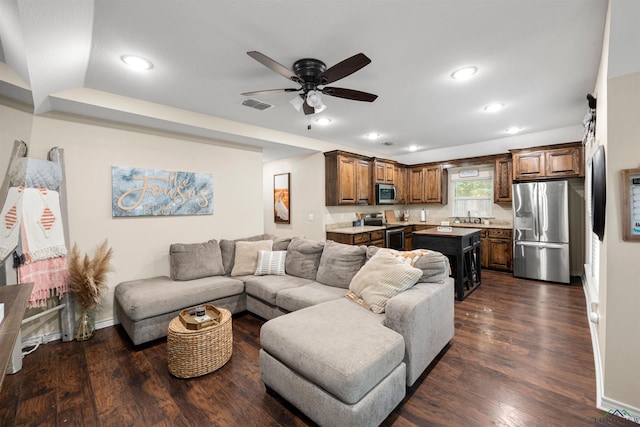 living room featuring dark hardwood / wood-style flooring, ceiling fan, and sink