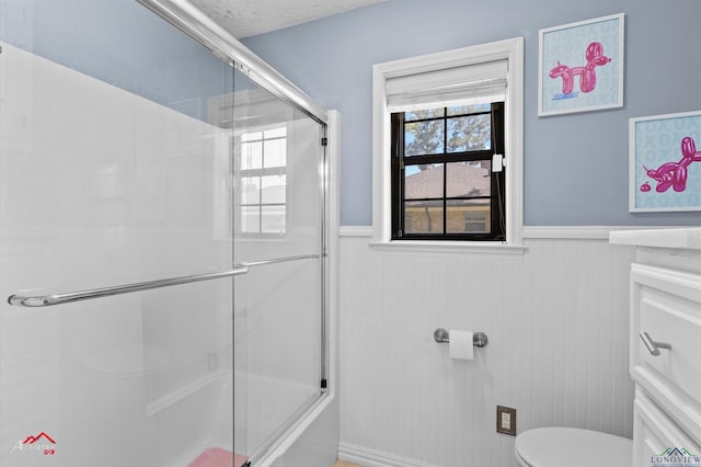1208 Westwood Dr, Henderson, TX 75654 - bathroom with a wainscoted wall, toilet, a shower with door, and a textured ceiling