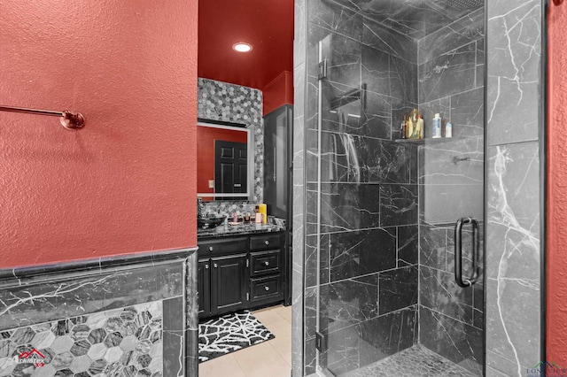 1208 Westwood Dr, Henderson, TX 75654 - full bath featuring vanity, a stall shower, tile patterned flooring, a textured wall, and wainscoting
