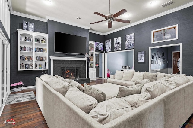 1208 Westwood Dr, Henderson, TX 75654 - living room with visible vents, ceiling fan, crown molding, a lit fireplace, and dark wood-style floors