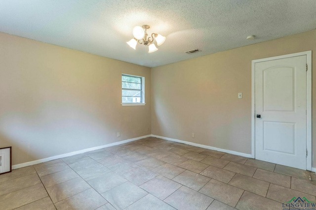 2820 W Upshur Ave, Gladewater, TX 75647 - tiled empty room with a chandelier, a textured ceiling, and baseboards