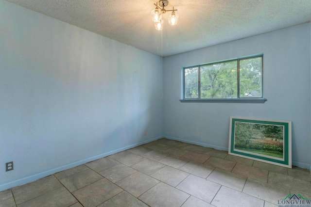 2820 W Upshur Ave, Gladewater, TX 75647 - tiled empty room with a textured ceiling and baseboards