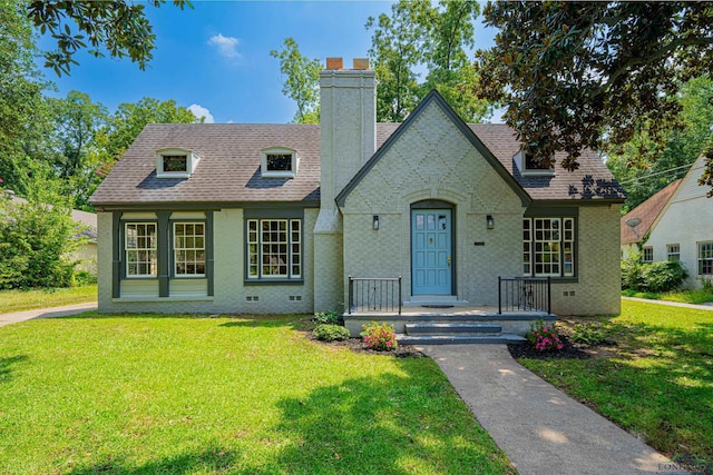 tudor home featuring a front lawn