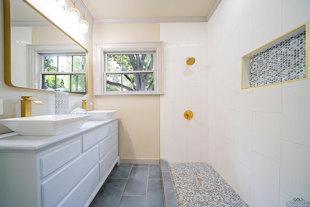 bathroom with a tile shower, crown molding, tile patterned flooring, and vanity