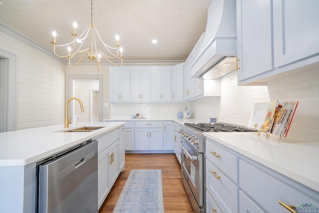 kitchen featuring custom exhaust hood, sink, white cabinetry, stainless steel appliances, and a chandelier