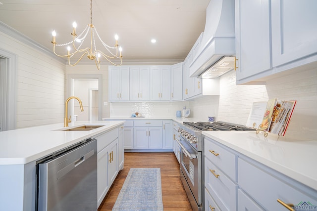 35 Covington Dr, Longview, TX 75602 - kitchen with appliances with stainless steel finishes, custom exhaust hood, a chandelier, light wood-style floors, and light countertops