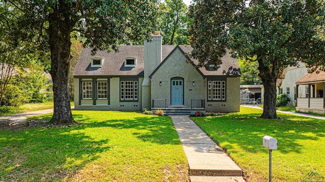 35 Covington Dr, Longview, TX 75602 - view of front facade featuring a chimney, a front lawn, and a shingled roof