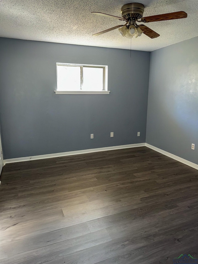 unfurnished room with a textured ceiling, a ceiling fan, baseboards, and dark wood-style flooring