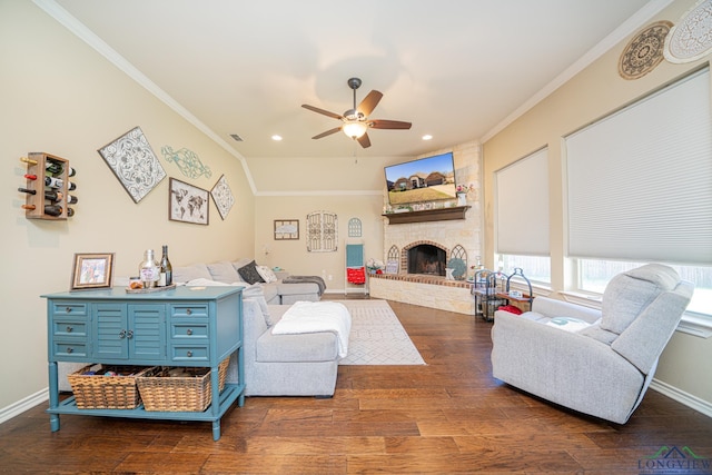 living room featuring a fireplace, dark hardwood / wood-style flooring, ceiling fan, and crown molding