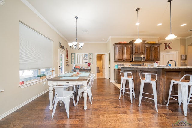 kitchen with light stone countertops, a kitchen breakfast bar, and an island with sink