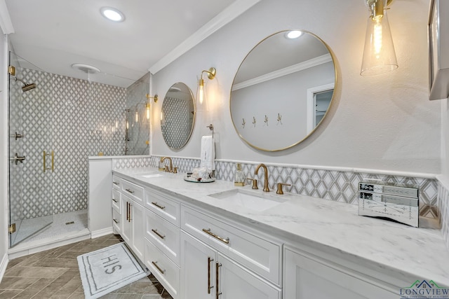 full bathroom featuring double vanity, crown molding, a stall shower, and a sink