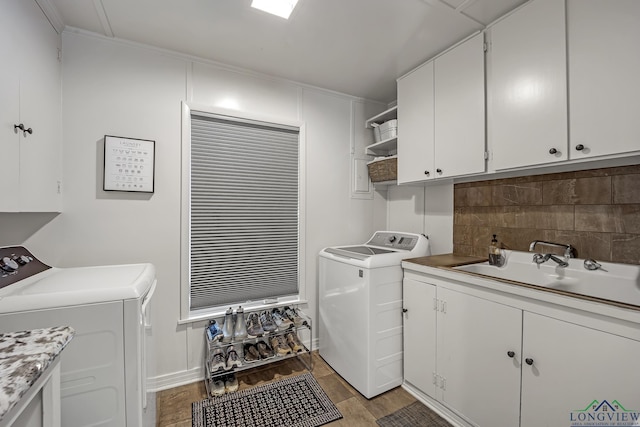 clothes washing area featuring cabinet space, light wood-type flooring, and washing machine and clothes dryer