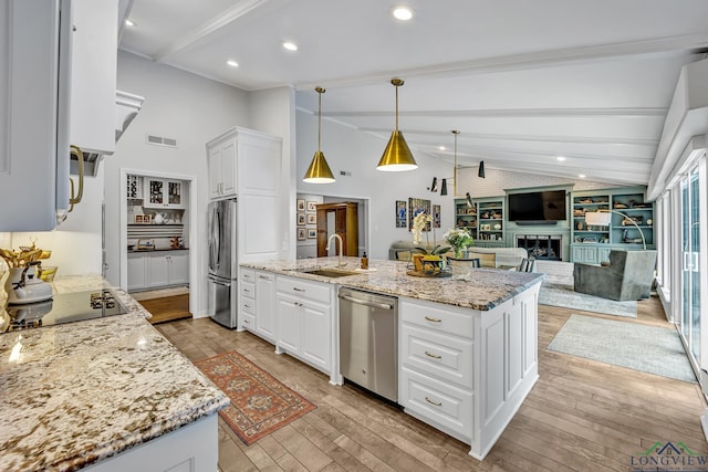 kitchen with white cabinets, a sink, vaulted ceiling with beams, visible vents, and appliances with stainless steel finishes