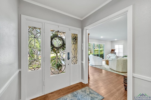 entrance foyer with wood finished floors and ornamental molding