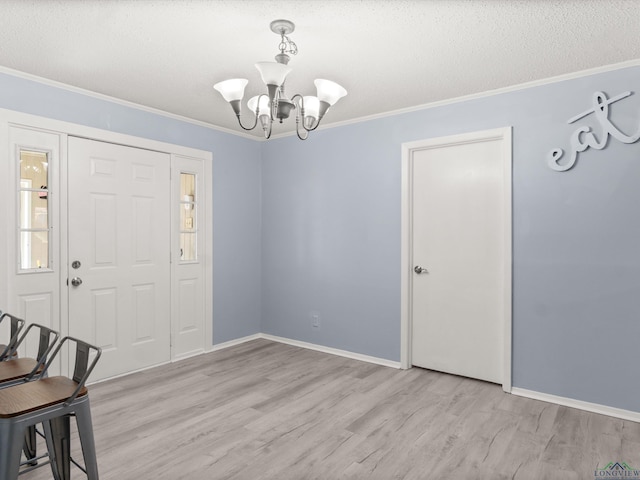 foyer featuring light hardwood / wood-style flooring, an inviting chandelier, and ornamental molding