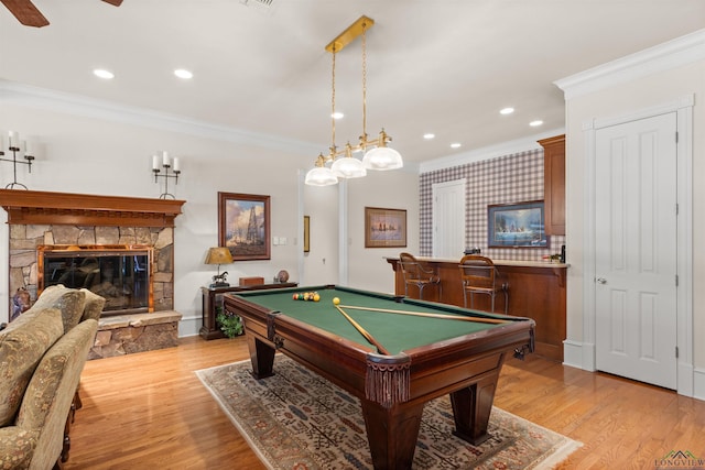 game room featuring crown molding, a fireplace, light hardwood / wood-style floors, and billiards