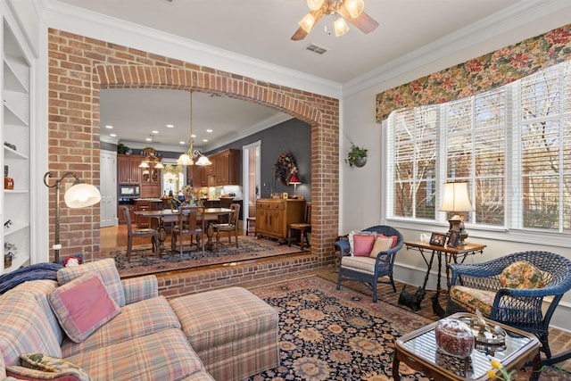 living room with ornamental molding and ceiling fan