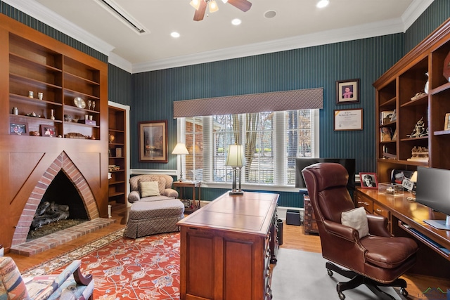 home office with a brick fireplace, built in features, ornamental molding, and ceiling fan