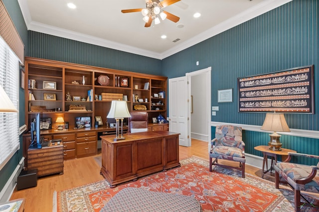 home office with crown molding, ceiling fan, and light wood-type flooring