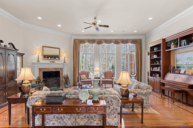 living room featuring crown molding, a fireplace, and light hardwood / wood-style floors