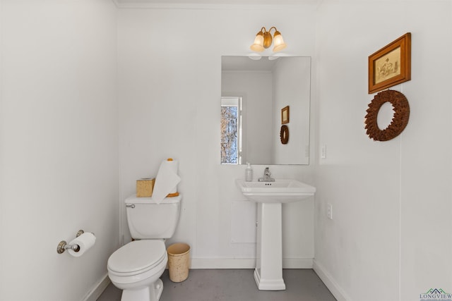 bathroom featuring concrete flooring, sink, and toilet