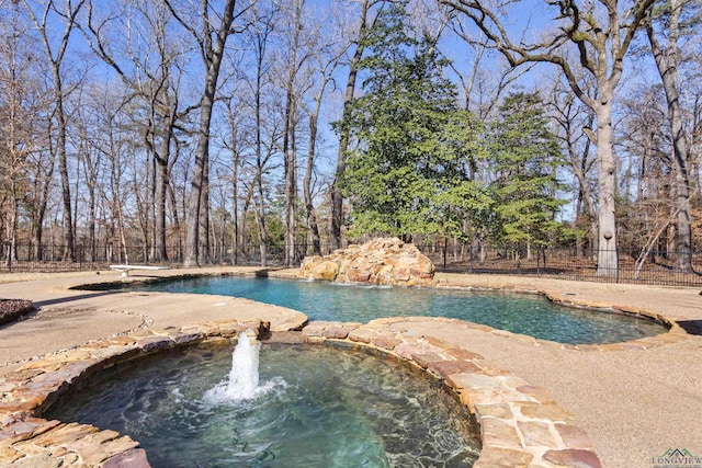 view of swimming pool with pool water feature