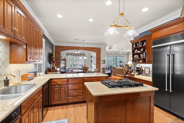 kitchen with sink, ceiling fan, appliances with stainless steel finishes, hanging light fixtures, and kitchen peninsula