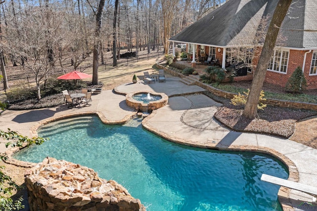 view of swimming pool with an in ground hot tub, a diving board, and a patio