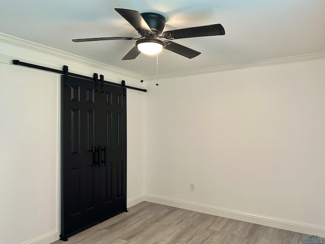 209 E Edgefield Ave, Longview, TX 75602 - spare room featuring a barn door, ceiling fan, crown molding, and light wood-type flooring