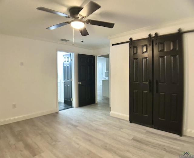 209 E Edgefield Ave, Longview, TX 75602 - unfurnished bedroom with a barn door, ornamental molding, light wood finished floors, ensuite bath, and ceiling fan
