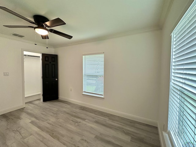 209 E Edgefield Ave, Longview, TX 75602 - unfurnished bedroom with crown molding, light wood-style flooring, ceiling fan, and a closet