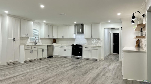 209 E Edgefield Ave, Longview, TX 75602 - kitchen with stainless steel appliances, wall chimney exhaust hood, light countertops, white cabinetry, and recessed lighting