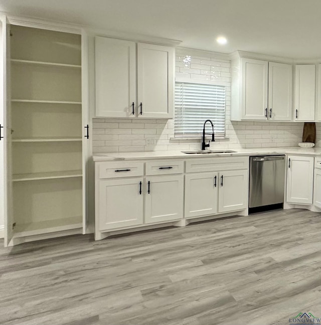 209 E Edgefield Ave, Longview, TX 75602 - kitchen featuring stainless steel dishwasher, white cabinetry, decorative backsplash, light countertops, and light wood finished floors