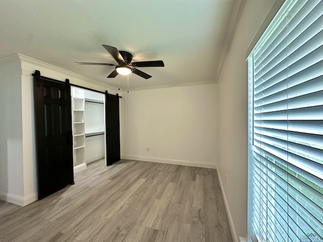 209 E Edgefield Ave, Longview, TX 75602 - unfurnished bedroom featuring light wood-style flooring, crown molding, a barn door, and ceiling fan