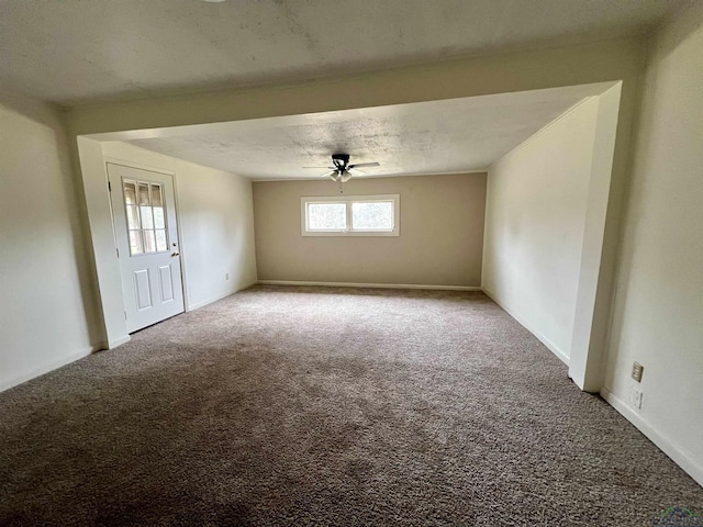 carpeted spare room featuring a textured ceiling and ceiling fan