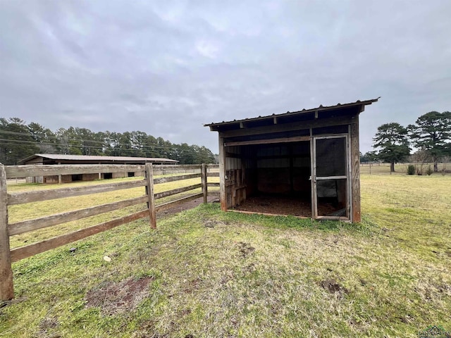 view of outdoor structure featuring a rural view and a yard