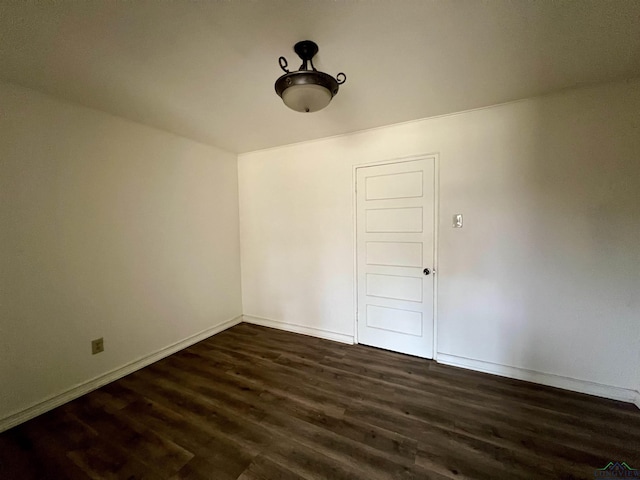 empty room with dark hardwood / wood-style flooring